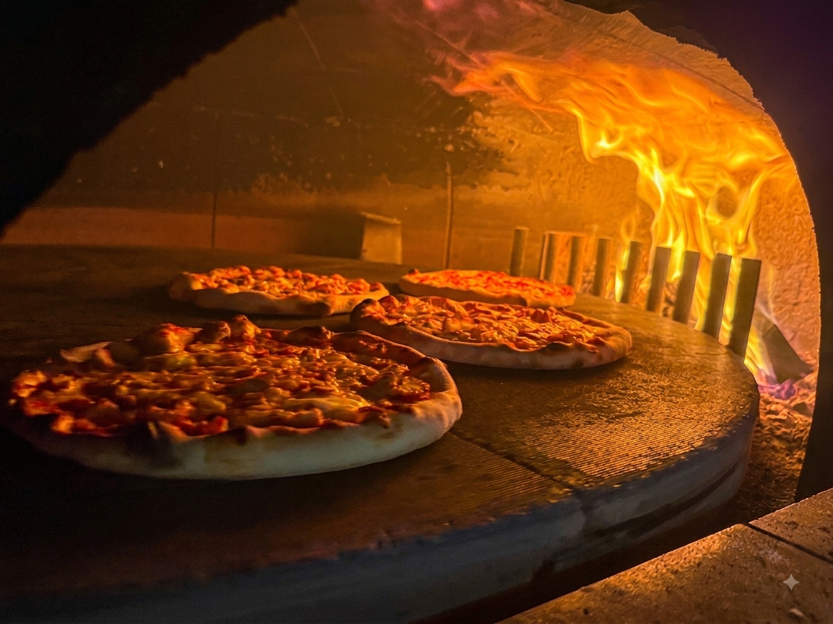 Pizzaer der bages i ægte stenovn med flammer hos Scandinavian Stenovns Pizza i Horsens